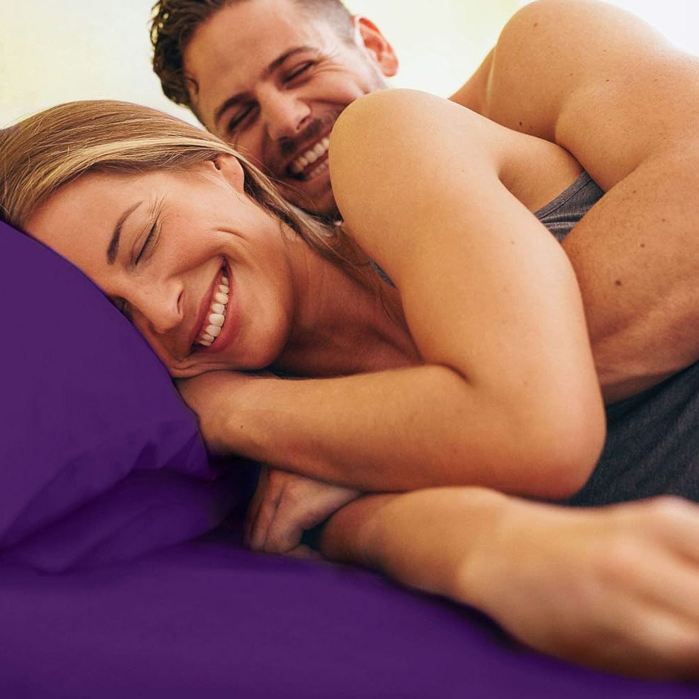 tes Man and woman laying in bed with Purple Sheets